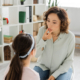 Speech therapist touching mouth during lesson with child in consulting room,stock image
