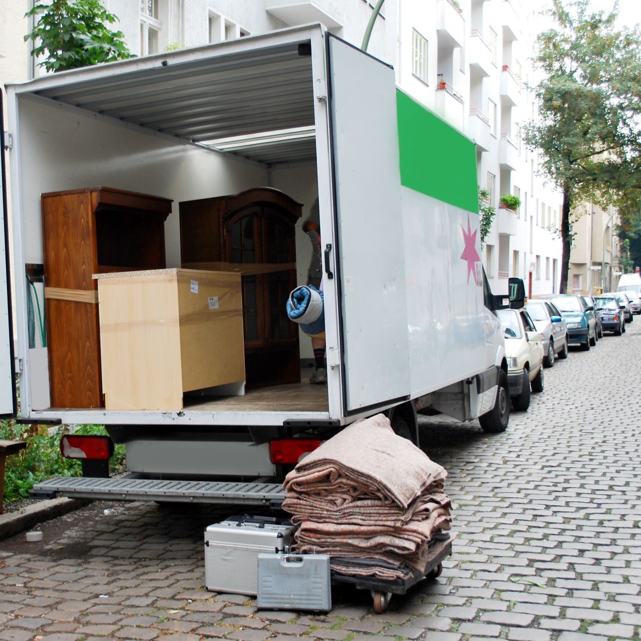 Ein geöffneter Umzugswagen mit Möbeln in einer Wohnstraße – professionelle Hilfe durch ein Umzugsunternehmen Wuppertal.