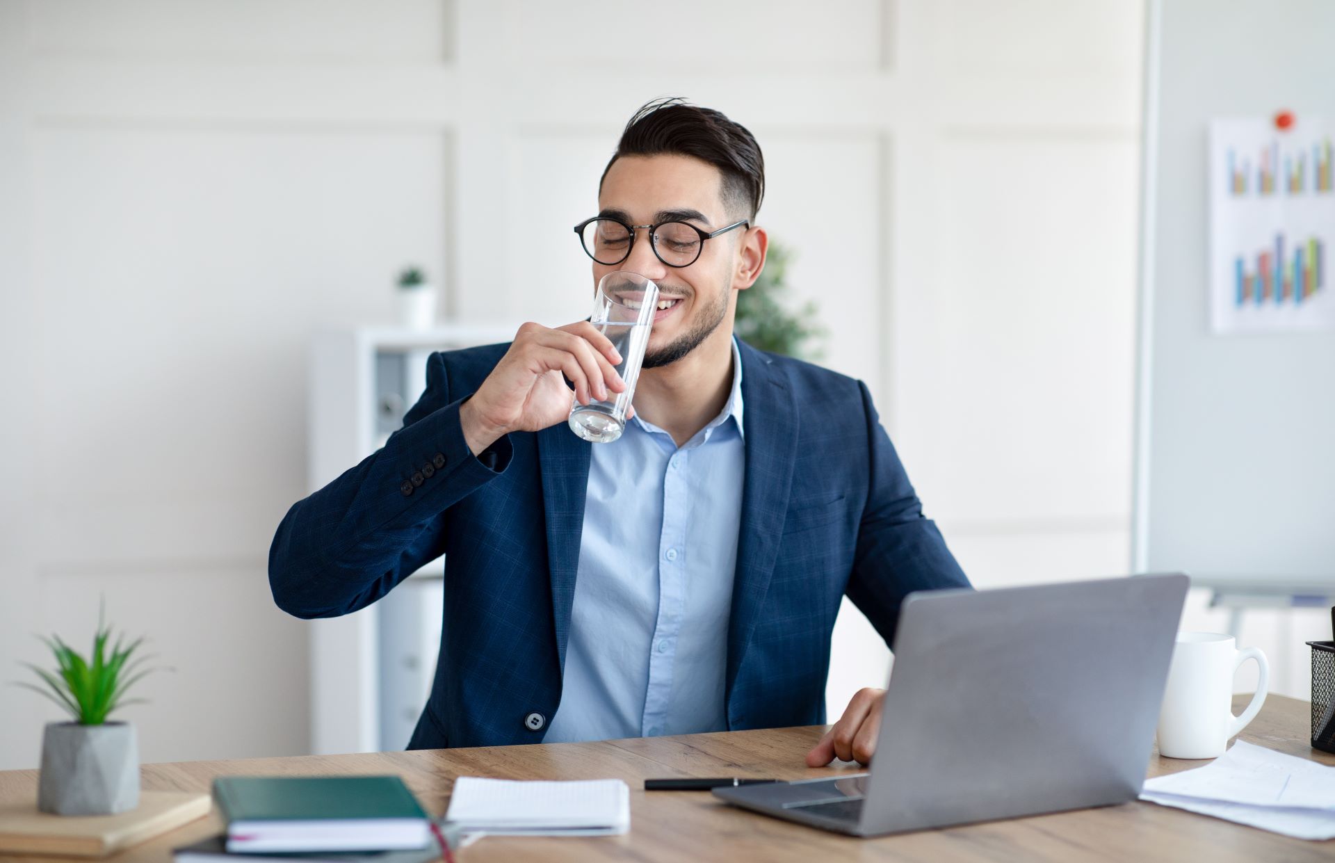 Geschäftsmann trinkt ein Glas Wasser im Büro.