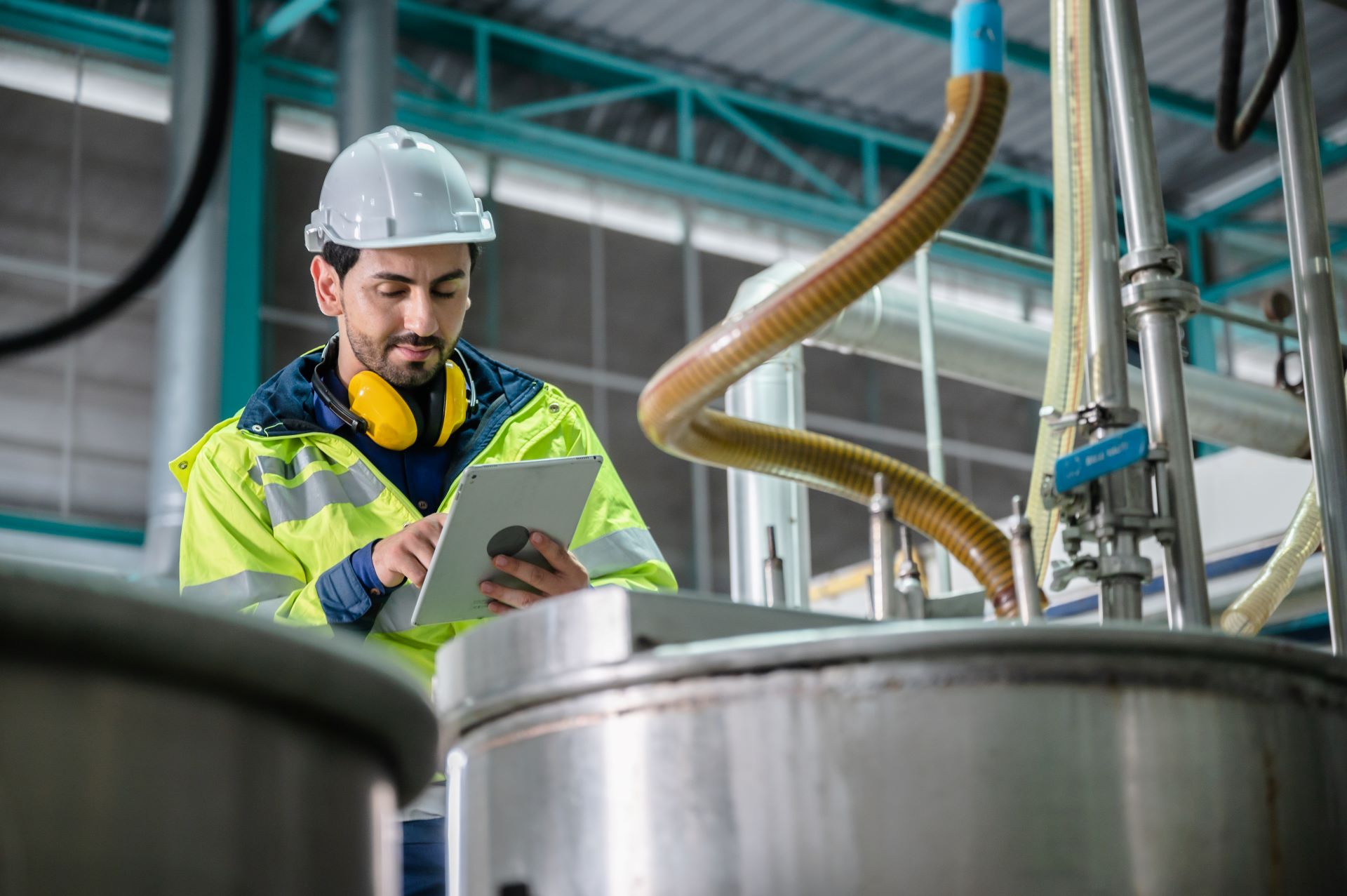 Ingenieur mit Tablet überprüft eine Industrieanlage.