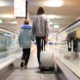 Mutter mit Kind und Rollkoffer unterwegs zum Abflug – kurze Wege nach dem Parken am Flughafen Nuernberg clever geplant