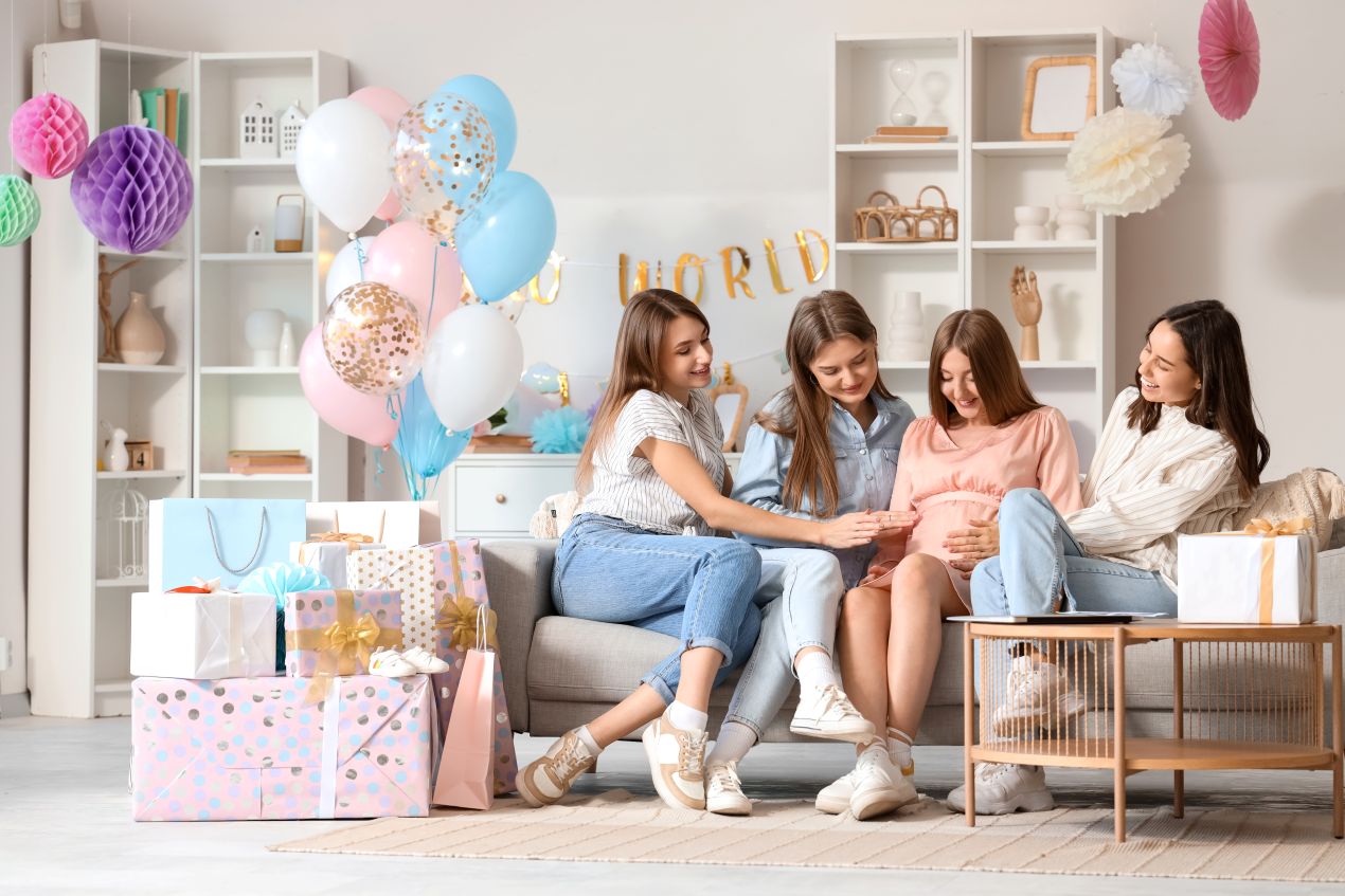 Freundinnen feiern eine Babyshower mit Geschenken – praesentkorb als liebevolle Idee zur Geburt oder Schwangerschaft
