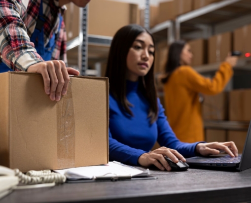 Team im Lager beim Versandprozess mit Luftpolstermaschine