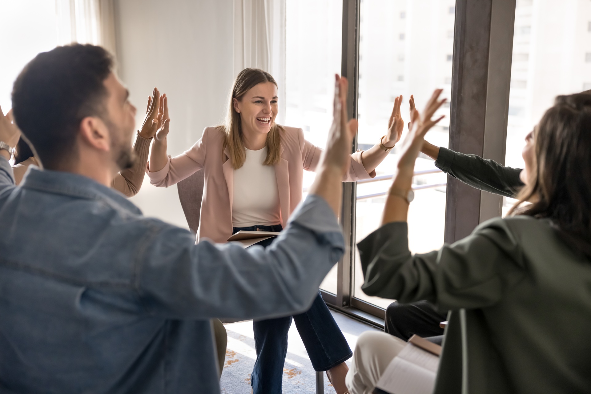 Motivierte Mitarbeiter in positivem Workshop geben High Five | Tagung Düsseldorf Location