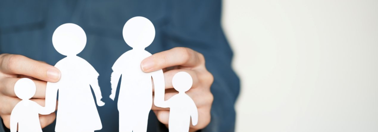 Papierausschnitt einer vierkoepfigen Familie auf Holztisch – Symbolbild fuer geteiltes Sorgerecht und moderne Familienmodelle