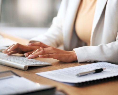 Frau arbeitet am Schreibtisch mit Tastatur und Dokumenten – Thema: Bueroservice Preise und Arbeitsentlastung im Backoffice