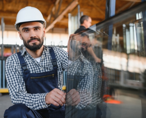 Fensterbauer bei der Montage eines Glaselements in der Werkstatt