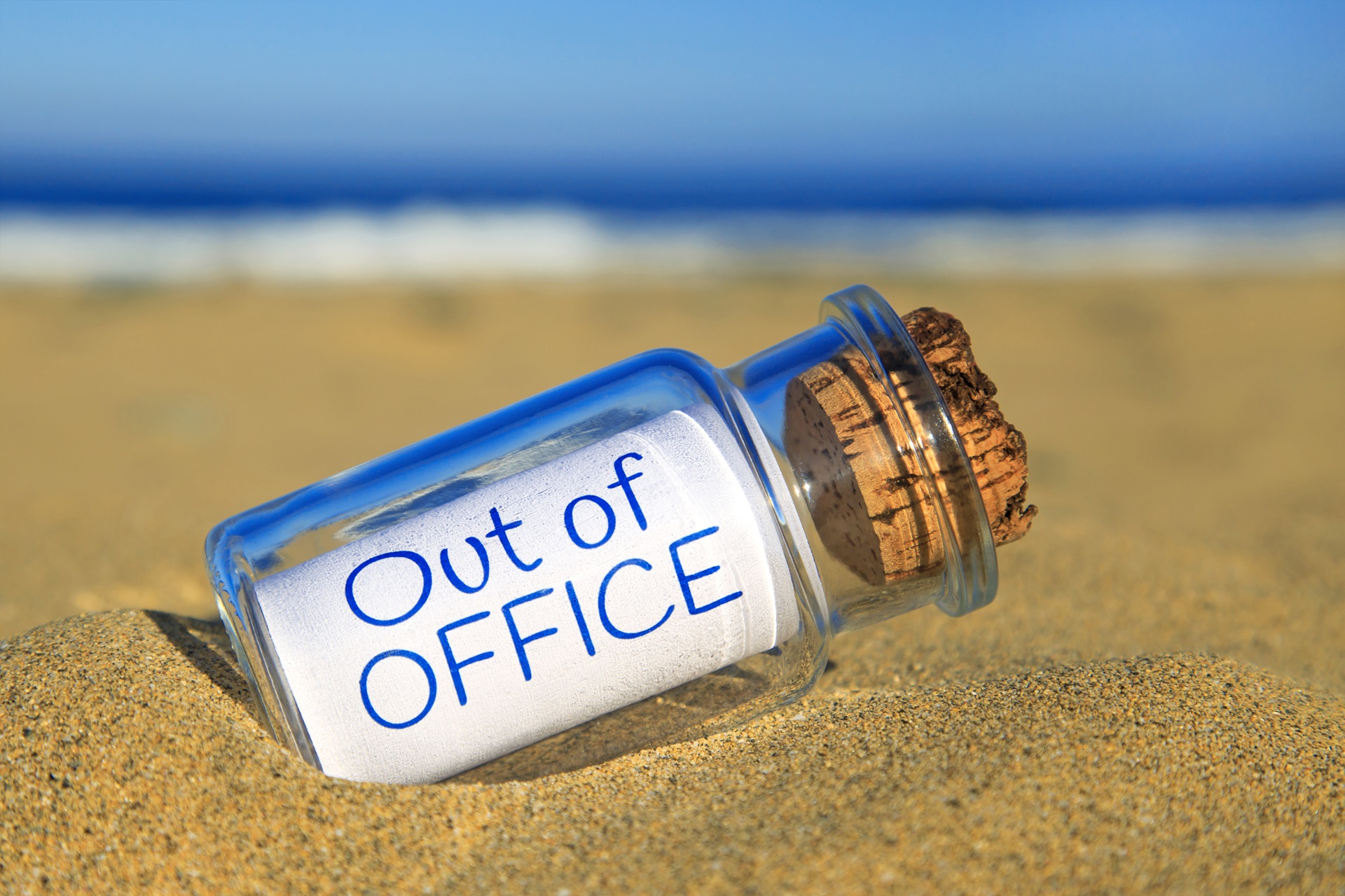 Flaschenpost mit Aufschrift Out of Office liegt im Sand | Wellnesshotel