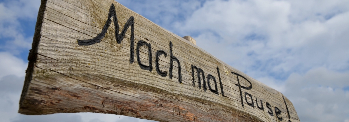 Holzschild mit Aufschrift Mach mal Pause vor Himmel | Wellnesshotel