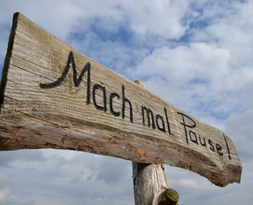 Holzschild mit Aufschrift Mach mal Pause vor Himmel | Wellnesshotel